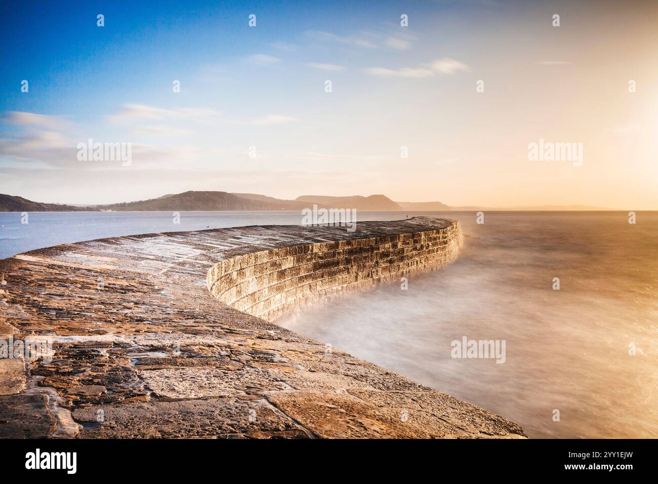 Sunrise oltre il Cobb a Lyme Regis nel Dorset. Foto Stock