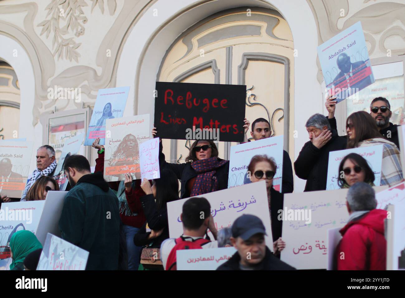 Tunisi, Tunisia, 18 dicembre 2024. Attivisti e manifestanti si riuniscono fuori dal teatro in viale Habib Bourguiba chiedendo diritti per i migranti che intraprendono il pericoloso attraversamento del Mediterraneo per raggiungere l'Italia e l'Europa. I partecipanti hanno denunciato il trattamento dell'Italia nei confronti dei migranti irregolari che raggiungono le sue coste, gli accordi della Tunisia con l'Italia e l'UE per arginare il flusso di arrivi irregolari in Europa e il "nuovo Patto sull'immigrazione e l'asilo” dell'UE. La manifestazione ha coinciso con la giornata internazionale dei migranti Foto Stock