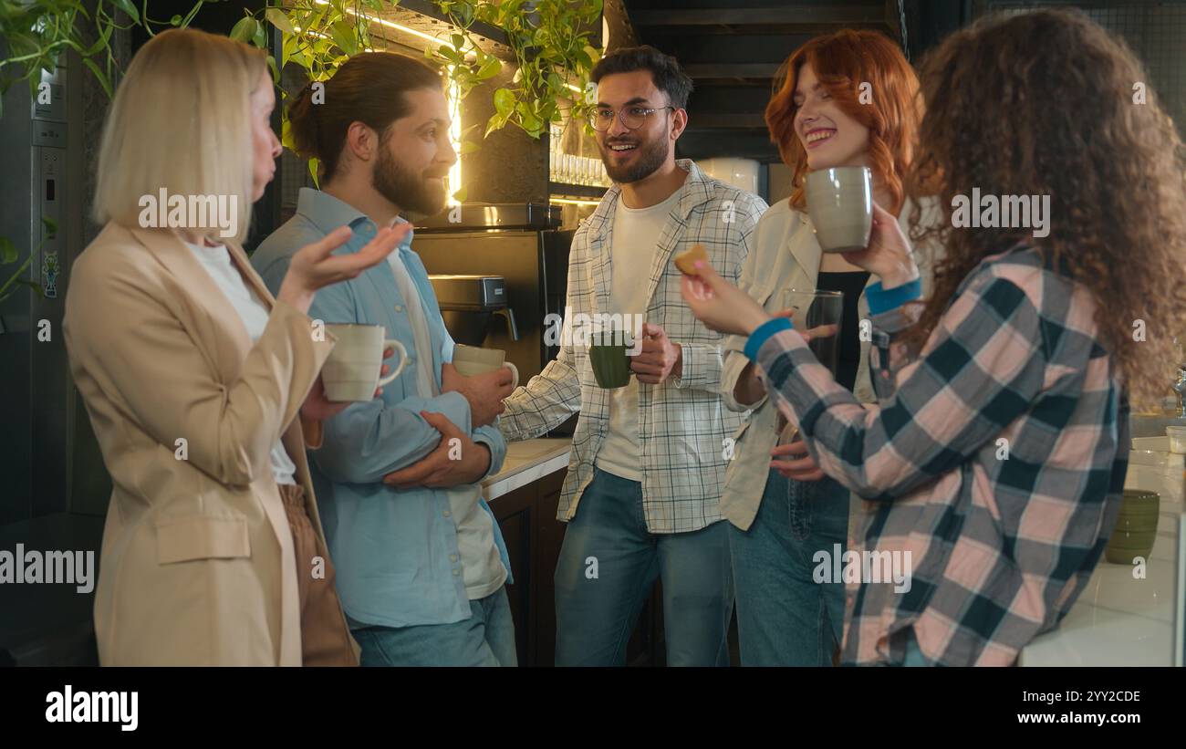 Colleghi multietnici amici maschio femmina bevendo caffè pausa in ufficio caffetteria squadra informale diverse ragazze ragazzi millennial studenti felici sorridenti Foto Stock