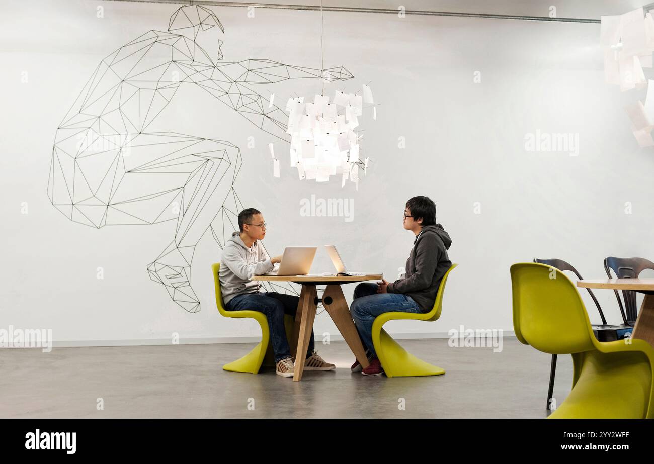 Monaco di Baviera, Germania - 04 febbraio. 2013: Un team creativo che si riunisce in un ufficio moderno a Monaco di Baviera con due giovani sconosciuti. Foto Stock