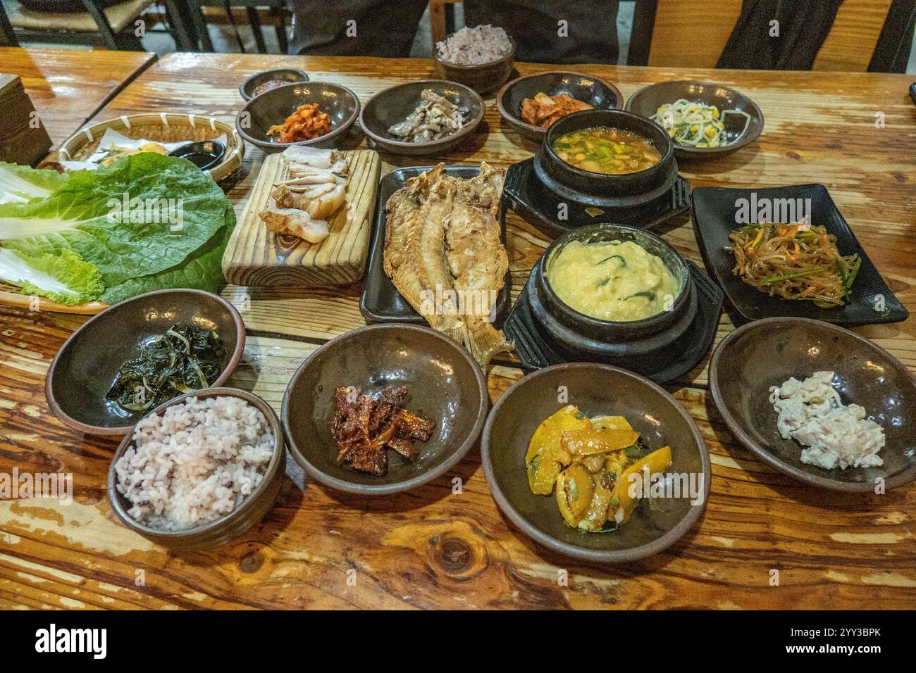 Tradizionale banchetto dell'isola di Jeju, pesce, maiale nero e contorni banchan, Seogwipo, Jeju, Corea del Sud Foto Stock