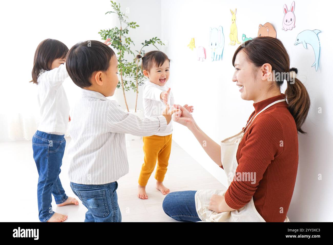 Bambini e insegnanti che giocano alla Festa dei bambini, alla scuola materna e all'asilo Foto Stock