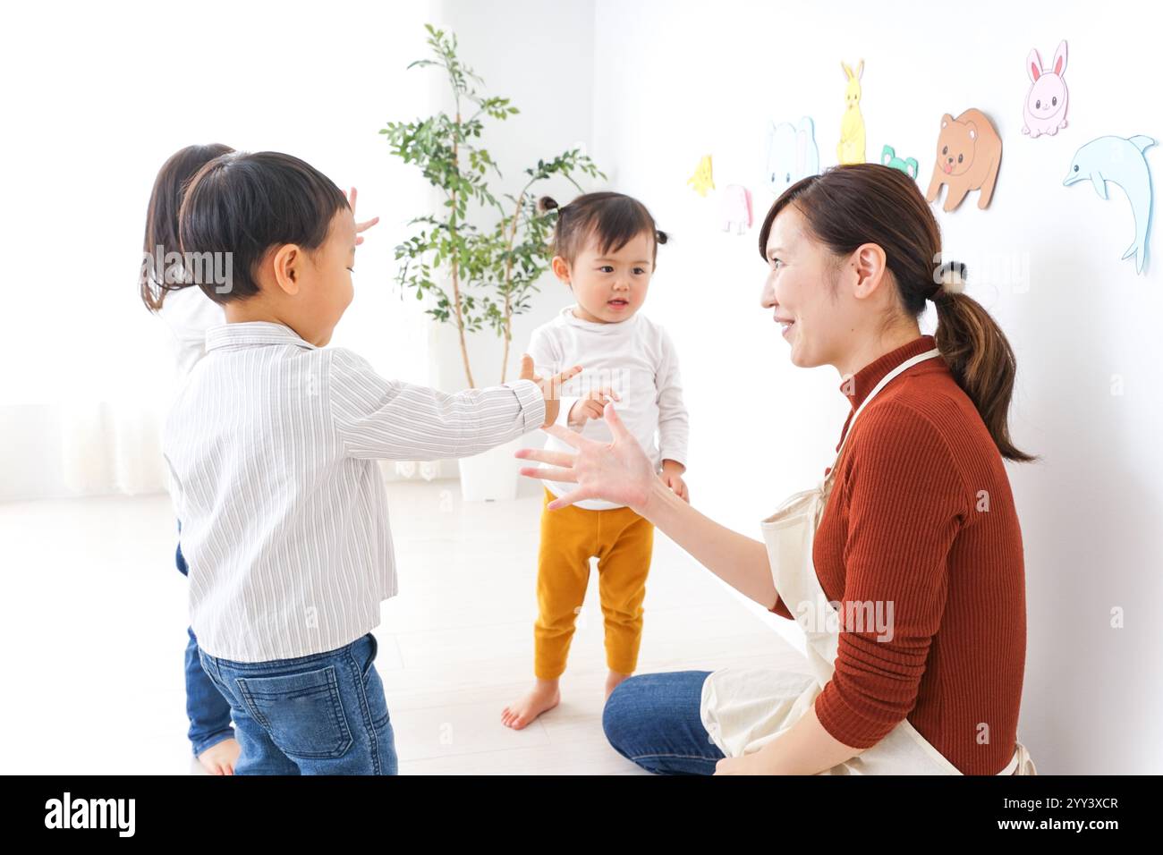Bambini e insegnanti che giocano alla Festa dei bambini, alla scuola materna e all'asilo Foto Stock