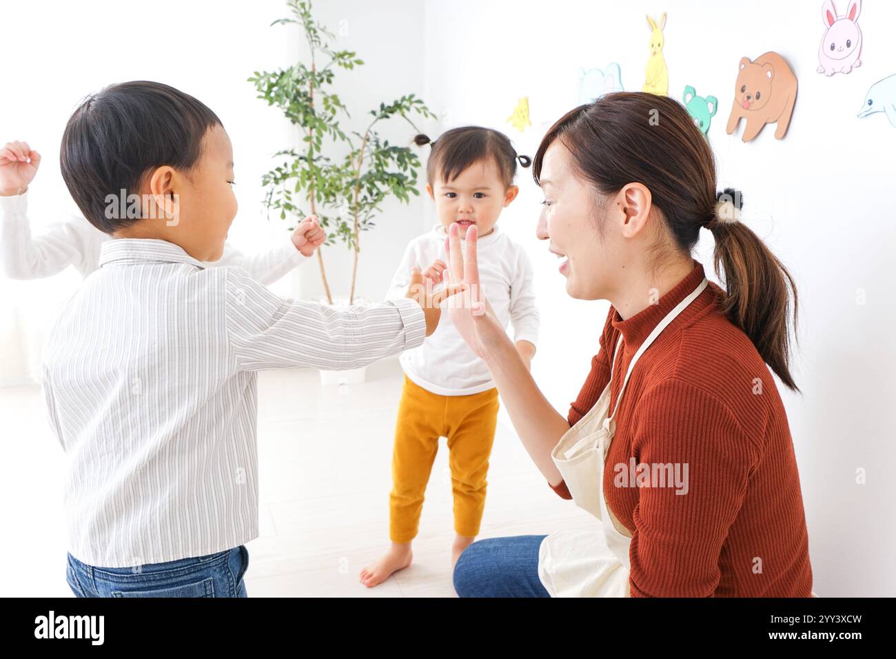Bambini e insegnanti che giocano alla Festa dei bambini, alla scuola materna e all'asilo Foto Stock