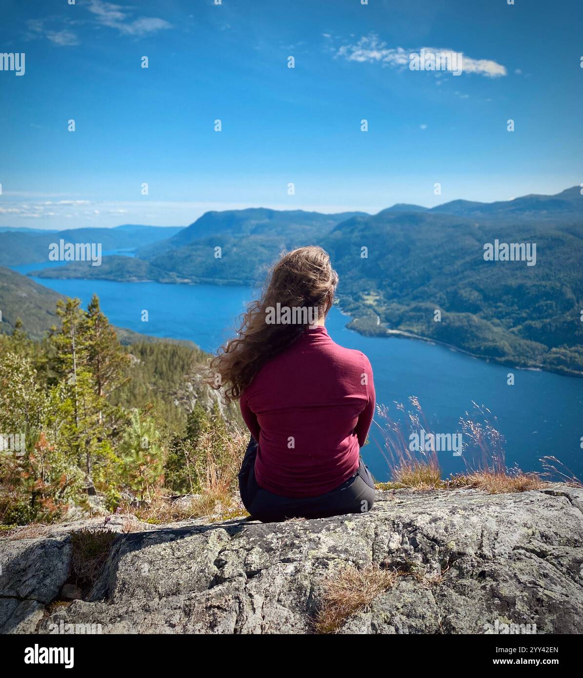 Una ragazza è seduta in cima alla montagna in Norvegia Foto Stock