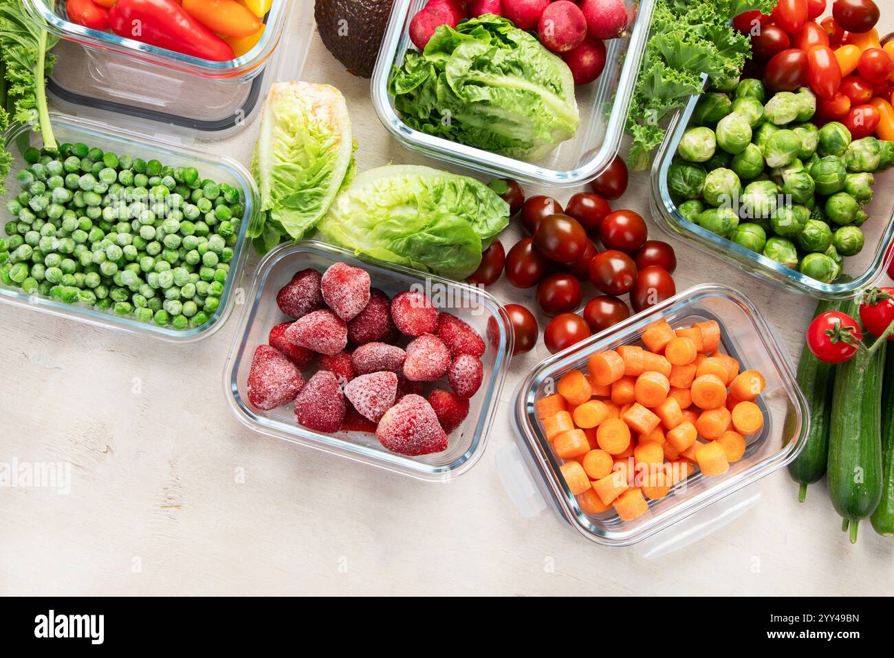 Contenitori in vetro con diversi prodotti freschi, come verdura e frutta, su uno sfondo chiaro. Vista dall'alto. Foto Stock