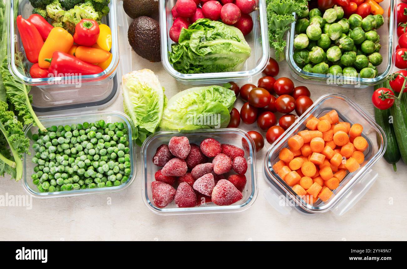 Contenitori in vetro con diversi prodotti freschi, come verdura e frutta, su uno sfondo chiaro. Vista dall'alto. Copia spazio. Foto Stock
