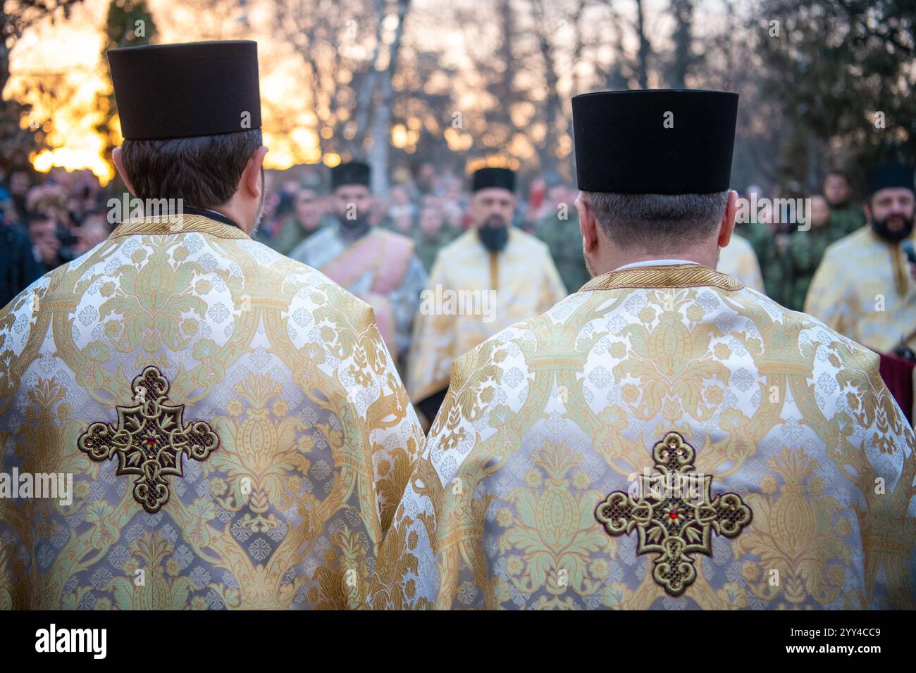 I sacerdoti serbi tengono la cerimonia prima di bruciare i rami di quercia essiccati - il simbolo di Yule per la ChristmasEve ortodossa di fronte alla chiesa di Santa Sava Foto Stock