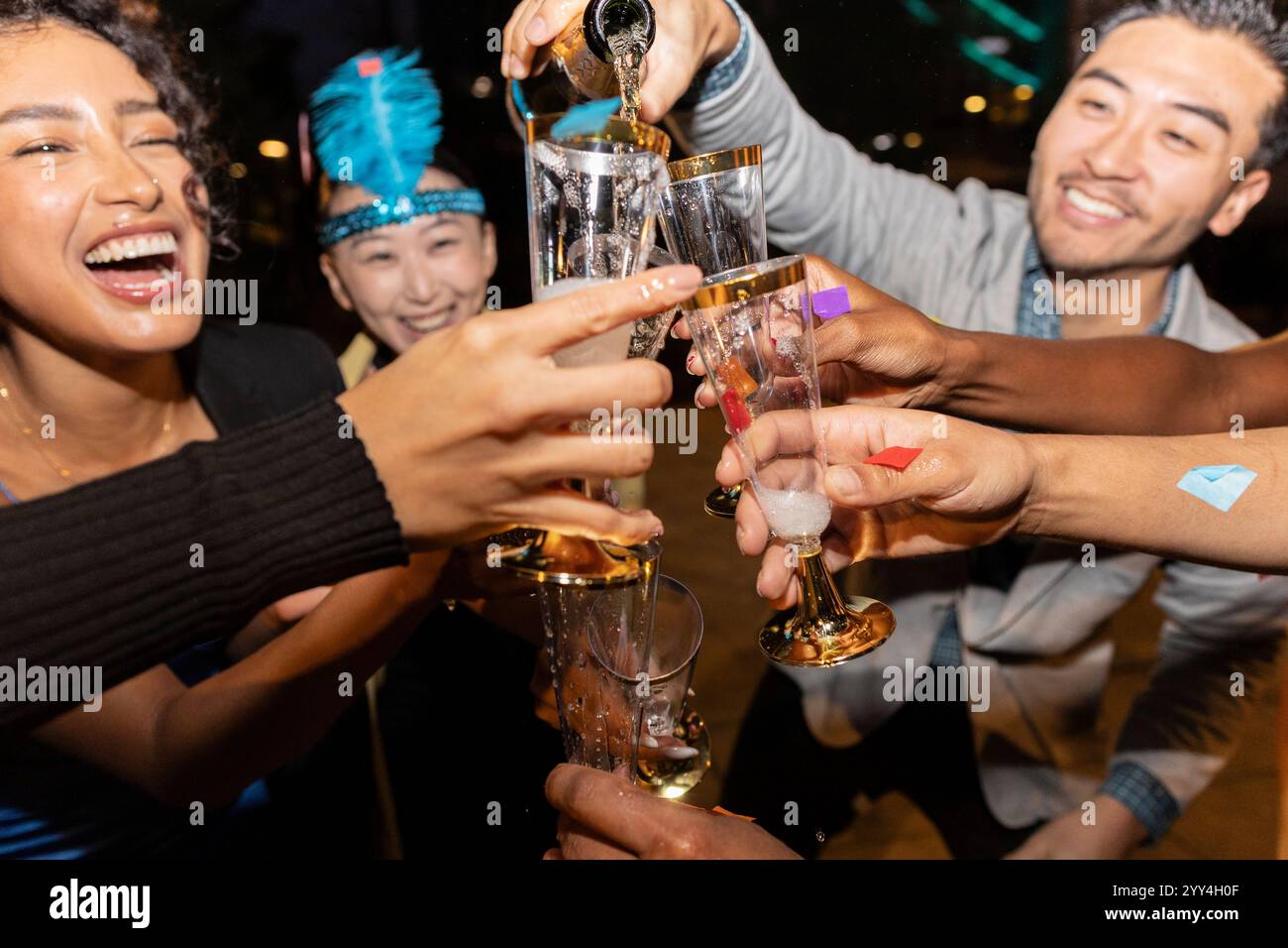 Una vivace festa cittadina dove gli amici si divertono a sorseggiare bicchieri e festeggiare insieme l'atmosfera è piena di gioia e risate, creando un'esperienza indimenticabile Foto Stock