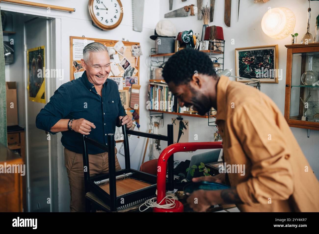 Felice proprietario e cliente senior che interagiscono tra loro in un negozio di antiquariato Foto Stock