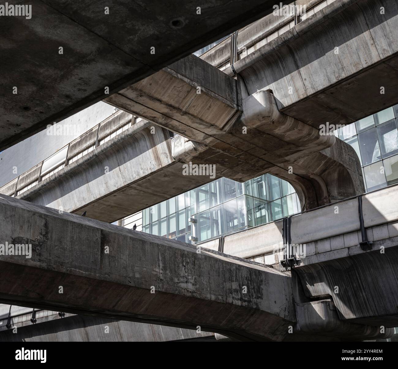 Bangkok, Tailandia, 16 novembre 2023 una vista astratta di strutture in cemento che sostengono la rete ferroviaria della città nel luminoso sole pomeridiano. Foto Stock