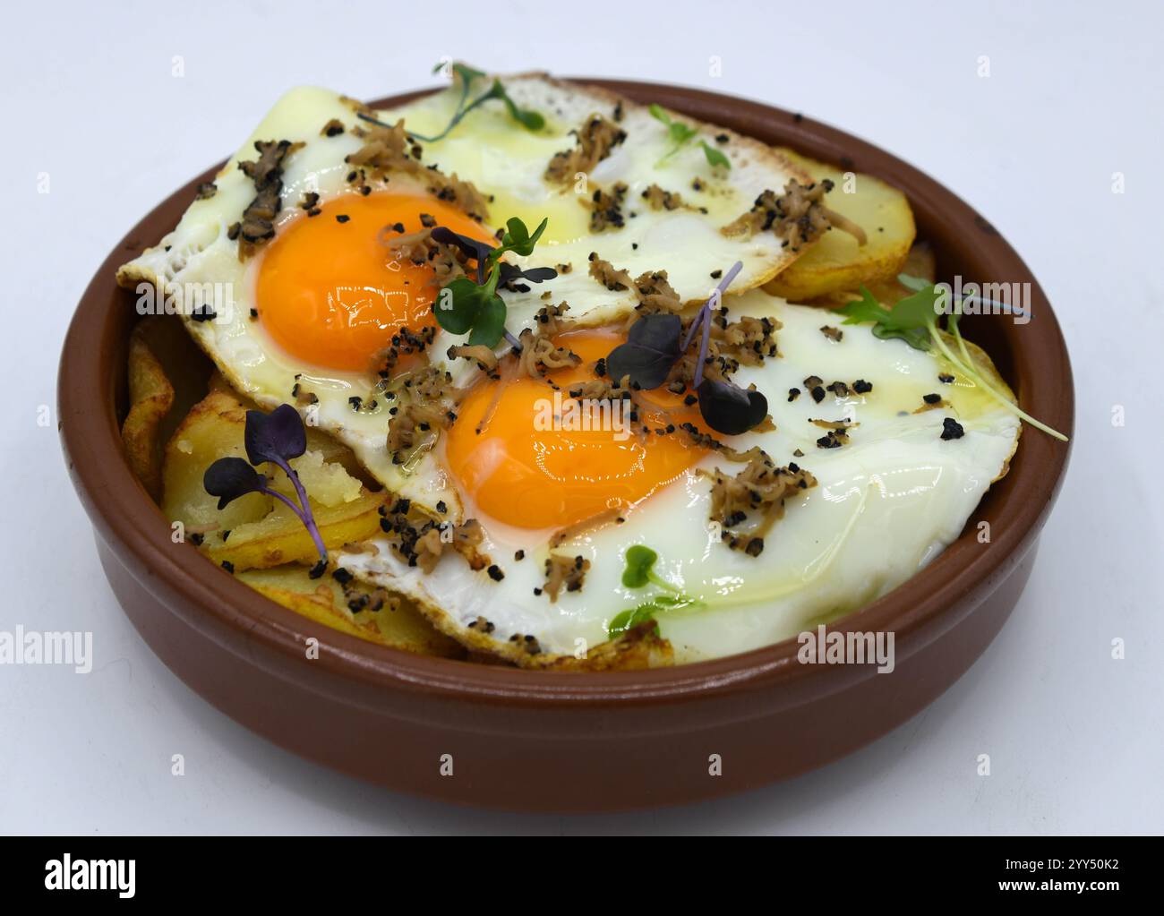 Uova fritte con patate su sfondo bianco Foto Stock