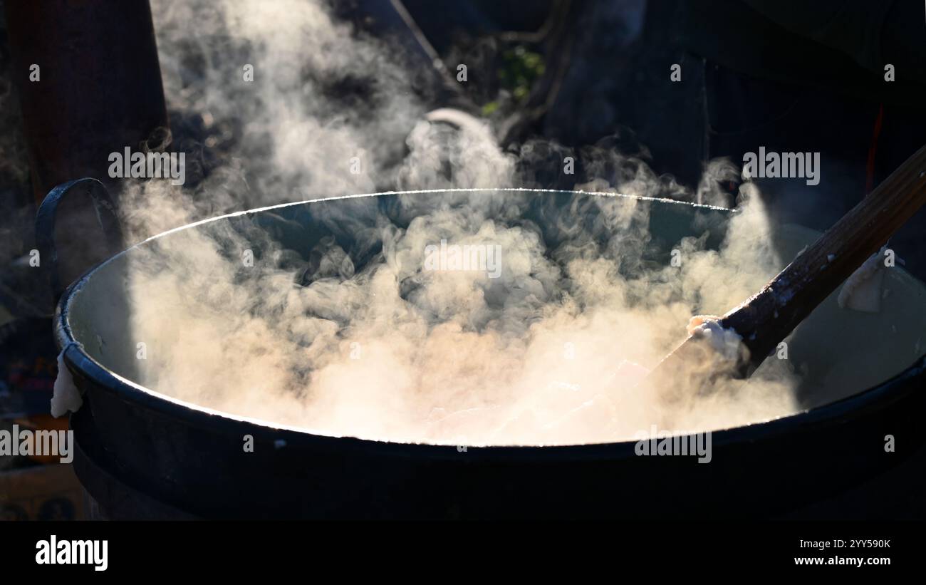 Ohrady, Dunajská Streda, Slovacchia - novembre 30 2024: Macellazione tradizionale di maiali della comunità del villaggio (zabíjačka), carne cucinata e mescolata all'esterno Foto Stock