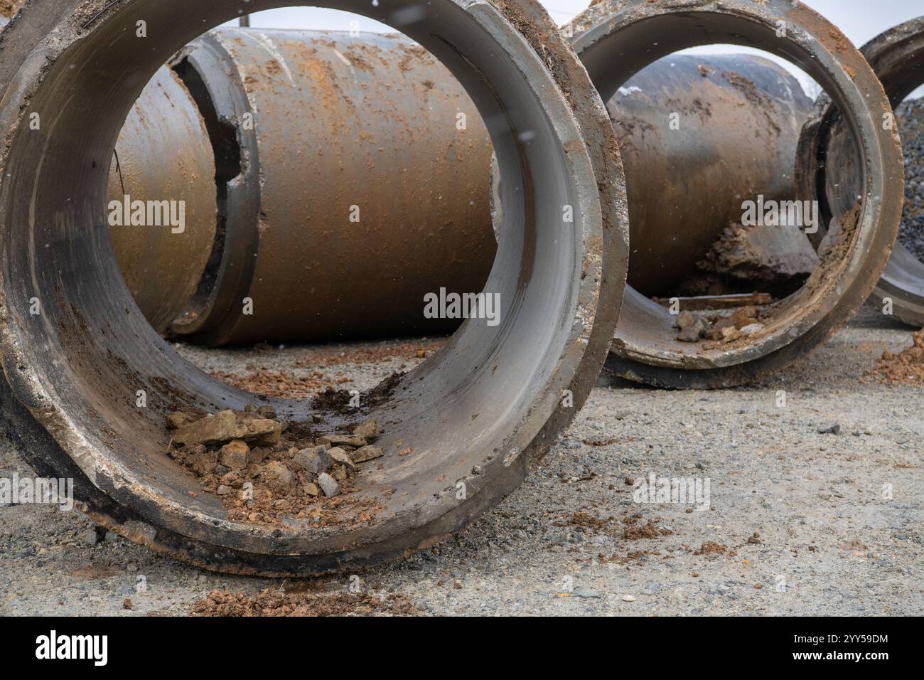 Pile di tubi di drenaggio in calcestruzzo impilato per pozzi e scarichi idrici, pronti per la costruzione. Background industriale. Foto Stock