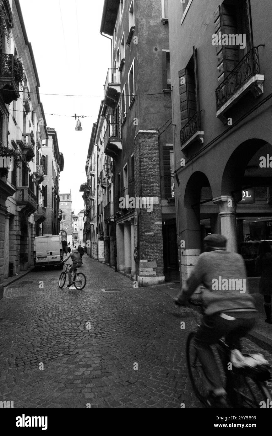Persone in bicicletta che attraversano una città italiana. Foto Stock