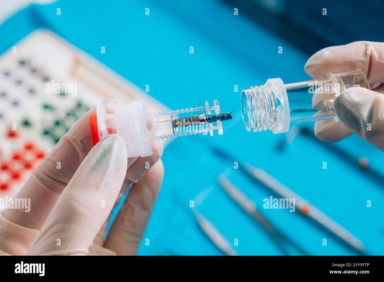 Mano che regge un impianto dentale Foto Stock