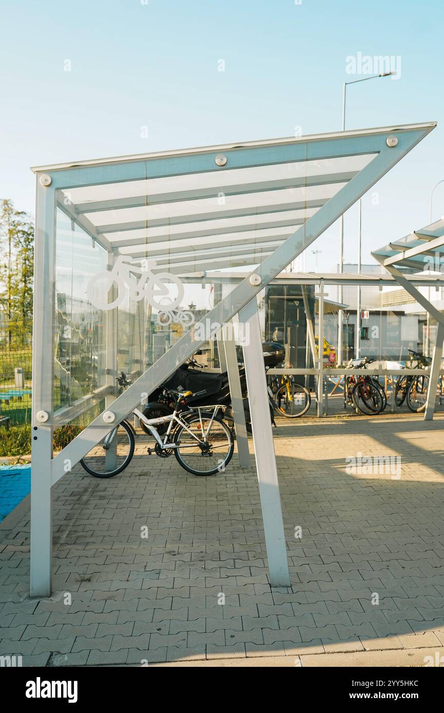 parcheggio con cavalletti per biciclette realizzati con tubi intrecciati lucidi, per inserire e bloccare la bicicletta sulla piazza. pavimentazione con interblocco e granito Foto Stock
