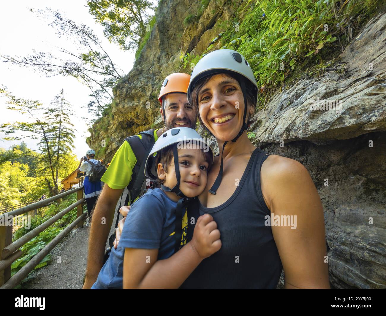 La famiglia partecipa a un'escursione attraverso la panoramica gola di vintgar vicino a Bled, in slovenia, indossando caschi per la sicurezza Foto Stock