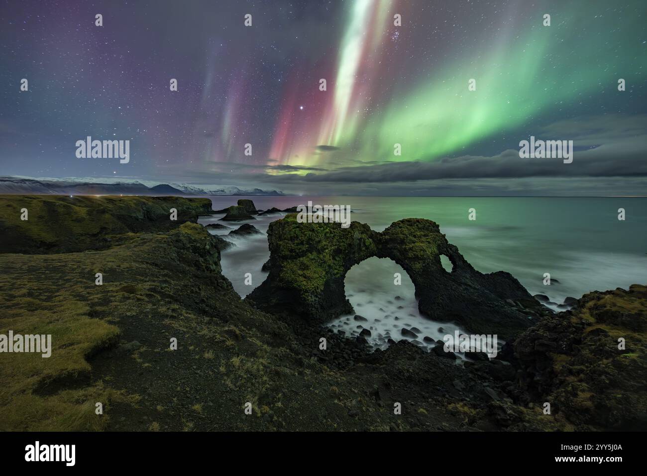Aurora boreale sulla struttura rocciosa, costa nei pressi di Arnarstapi, penisola di Snaefellsnes, Snaefellsnes, Islanda occidentale, Islanda, Europa Foto Stock