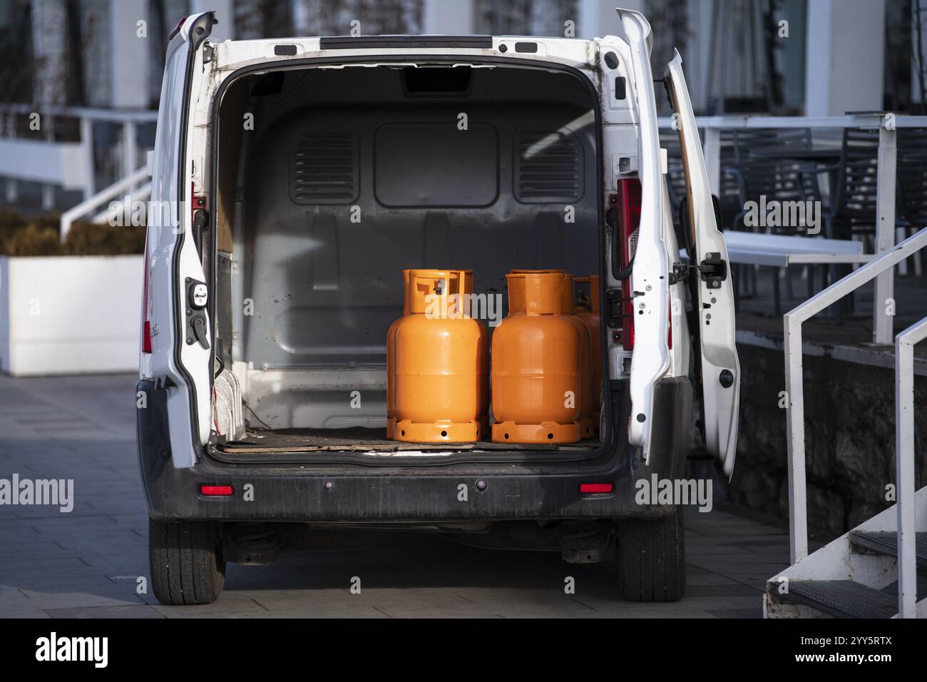 Bombole di gas arancioni trasportate all'interno di un pick-up. Bombole di gas butano nel camion pronte per la consegna. Veicolo che fornisce merci pericolose, gas compresso Foto Stock