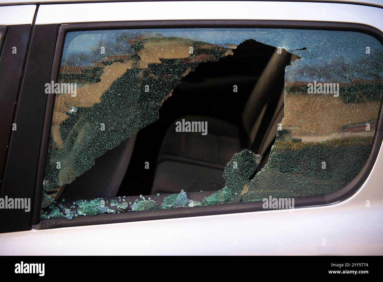 Finestra rotta e rapimento di cose da un'auto. Un incidente criminale. Hackerare la macchina. Finestrino sinistro rotto di un'auto. Foto Stock Finestra rotta e rapimento di cose da un'auto. Un incidente criminale. Hackerare la macchina. Finestrino sinistro rotto di un'auto. Foto Stock