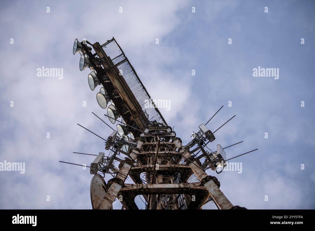 Luci dello stadio. Vecchio e enorme sistema di faretti su sfondo blu. Struttura a torre in metallo invecchiato con potenti lampade per illuminare lo stadio Foto Stock