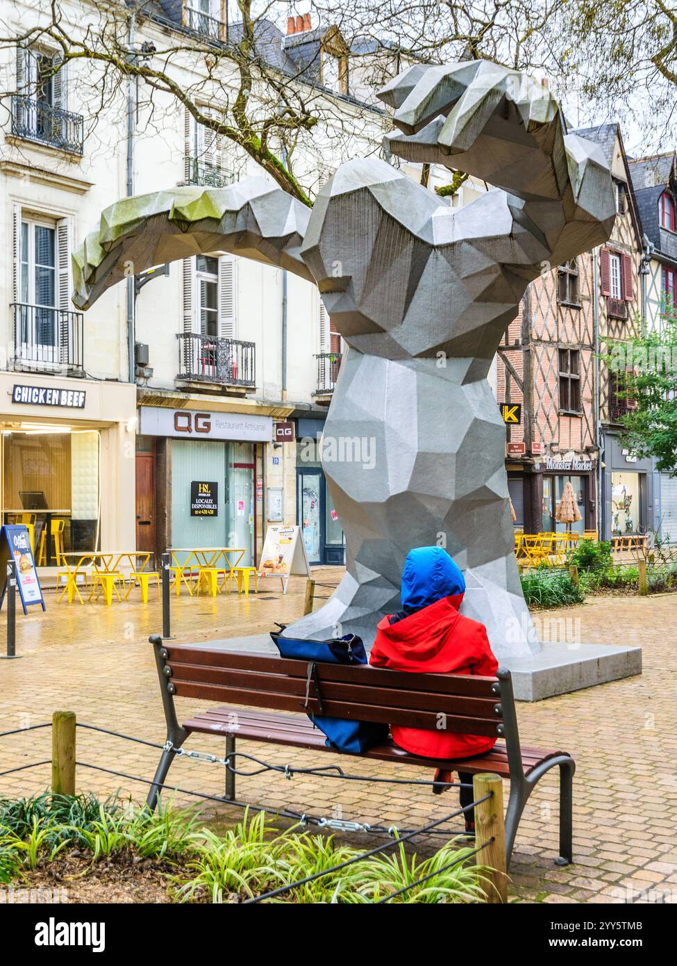 Persona sola seduta sotto le braccia allungate della scultura "le Monstre" di Xavier Veilhan a Tours, Indre-et-Loire (37), Francia. Foto Stock