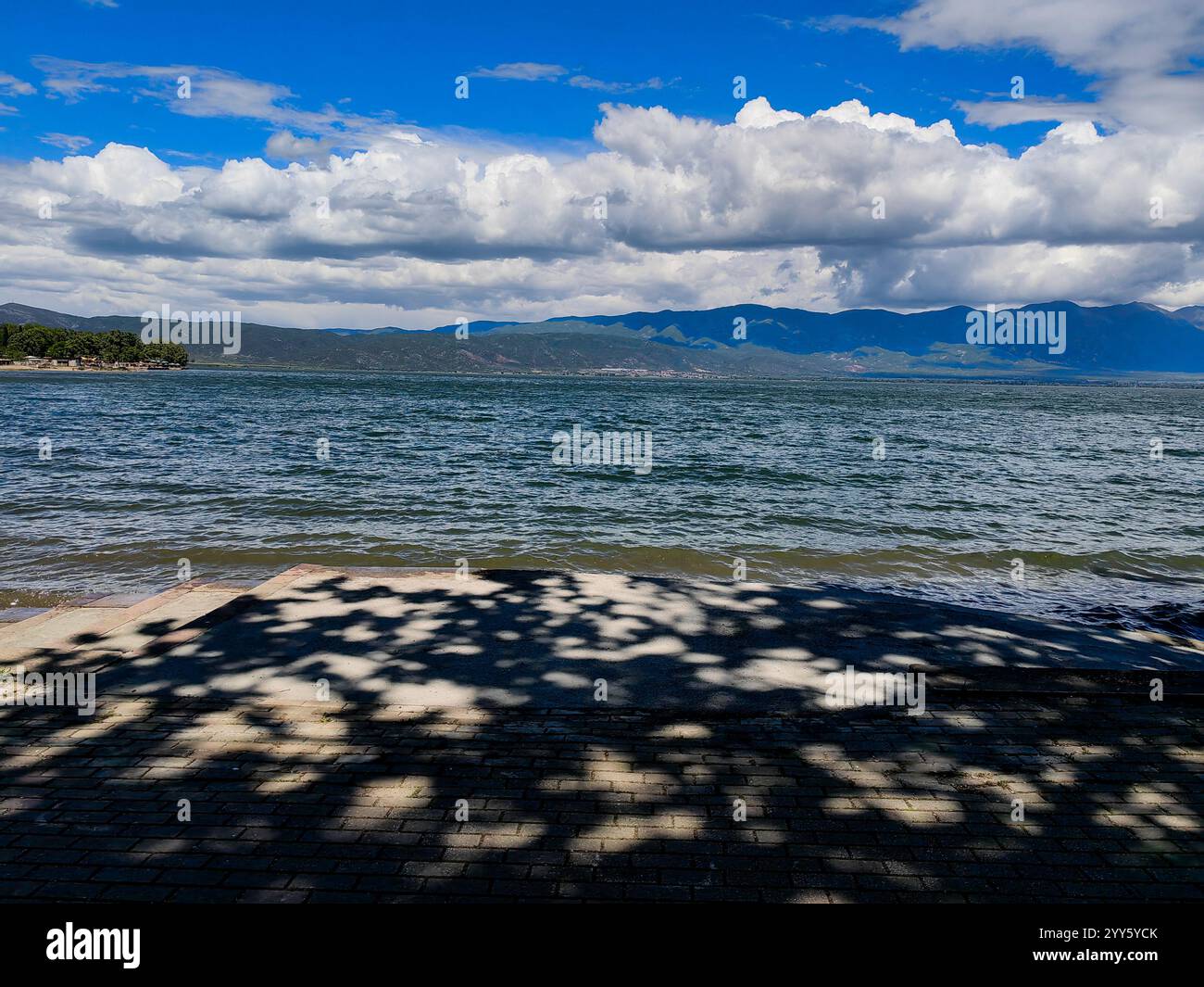 Sagome su cemento. Cieli attraversati dalle nuvole sopra il lago. Foto Stock
