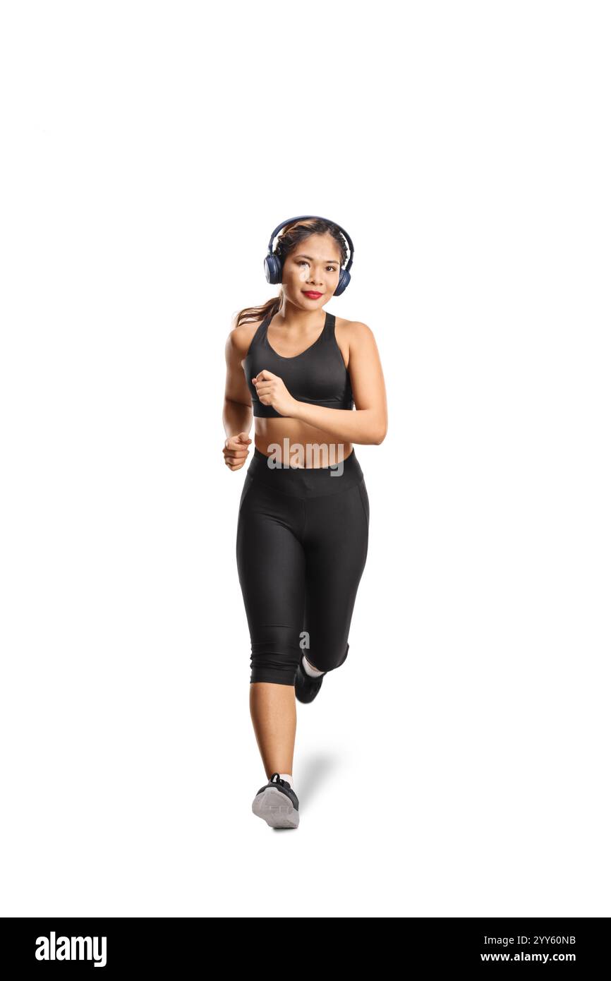 Giovane donna asiatica che fa jogging con le cuffie isolate su sfondo bianco Foto Stock