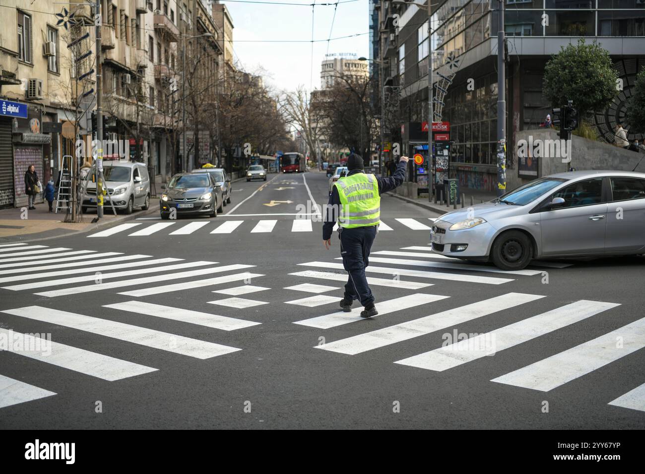 Un agente di polizia controlla l'incrocio, l'attraversamento pedonale, l'attraversamento di nuova zebra X o l'attraversamento diagonale su un grande incrocio nel centro di Belgrado Foto Stock