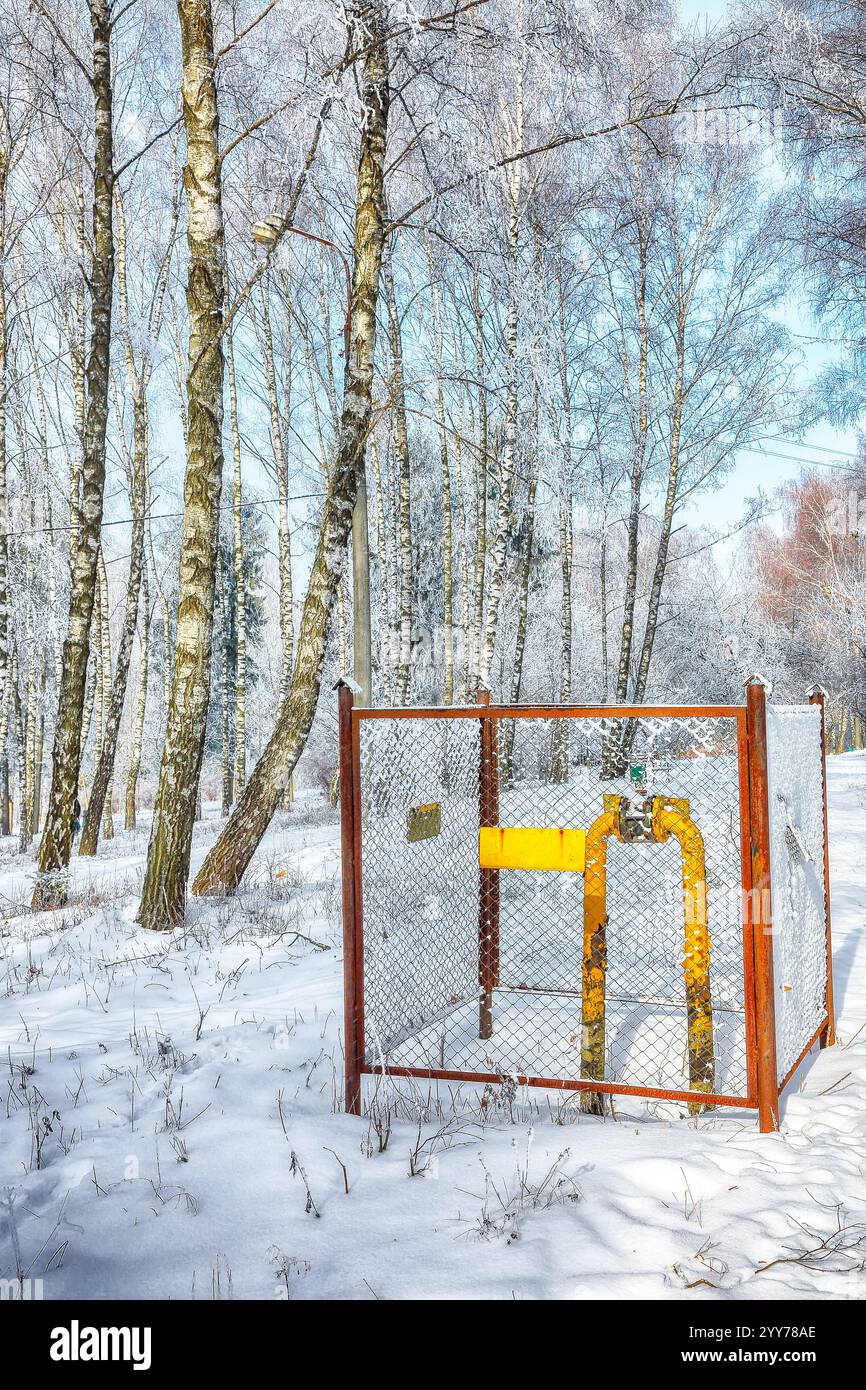 Vista sul vecchio tubo del gas giallo con una gru in un parco invernale. Paesaggio invernale Foto Stock