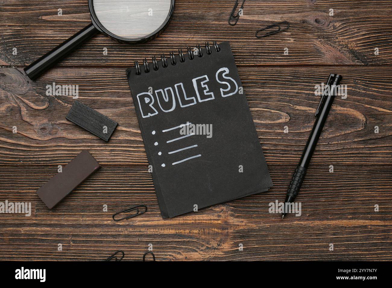 Quaderno con elenco vuoto di regole e cancelleria su sfondo in legno Foto Stock