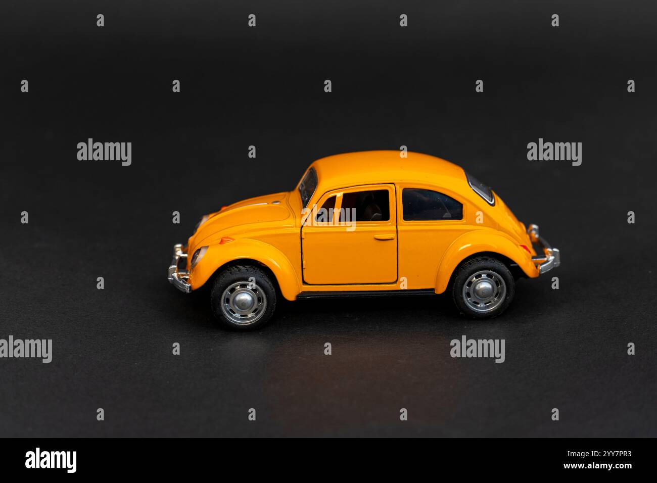 Scala del modello di auto giocattolo gialla su sfondo nero Foto Stock