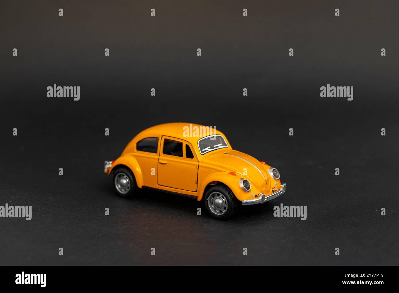 Vista frontale di un'auto giocattolo gialla su sfondo nero Foto Stock