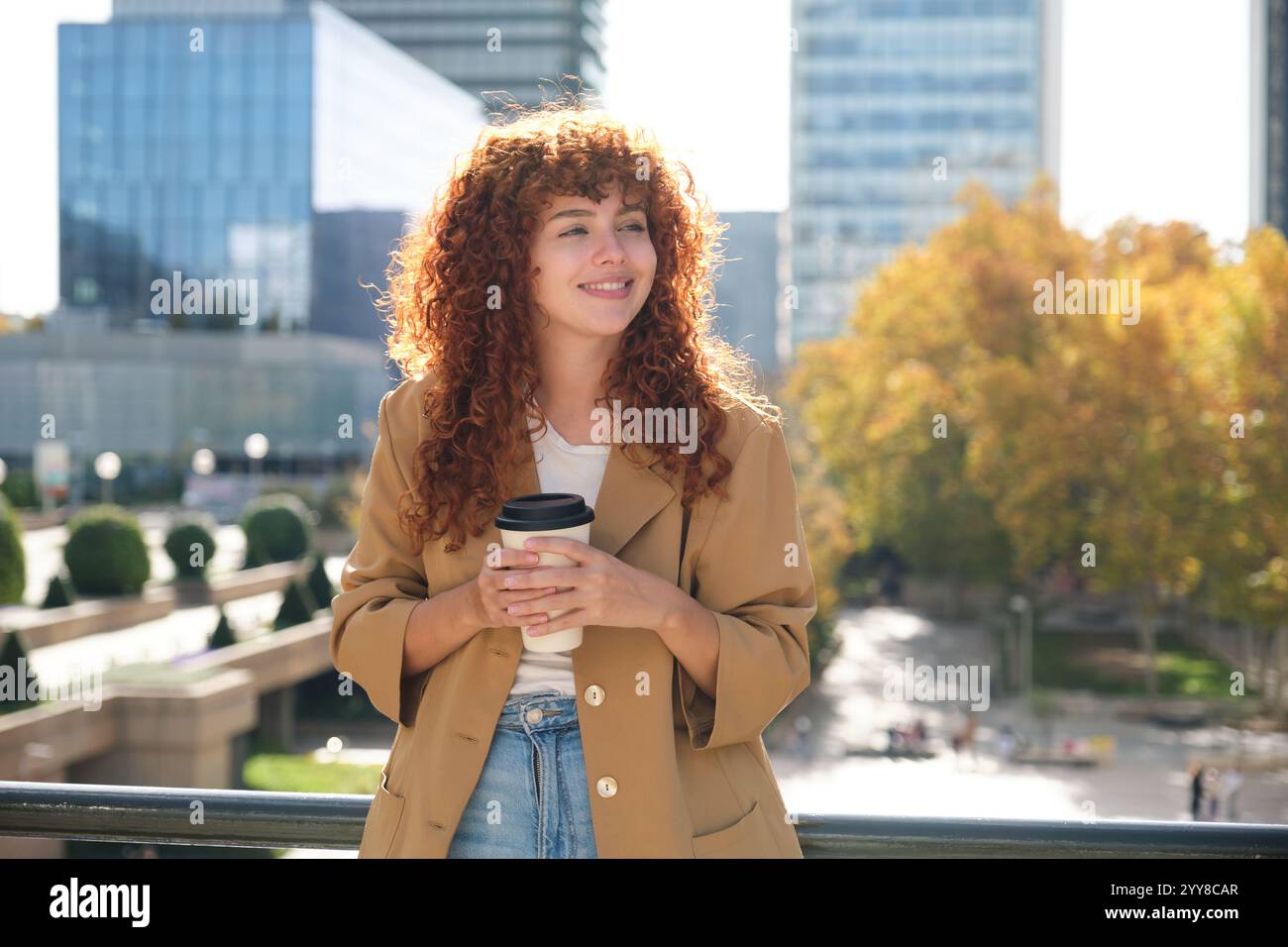 Donna d'affari felice che tiene in mano una tazza di caffè durante la pausa Foto Stock