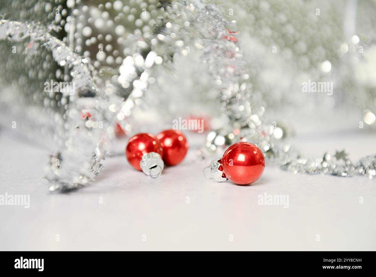 Primo piano di ornamenti rossi e tinsel argento con un blu festoso Foto Stock