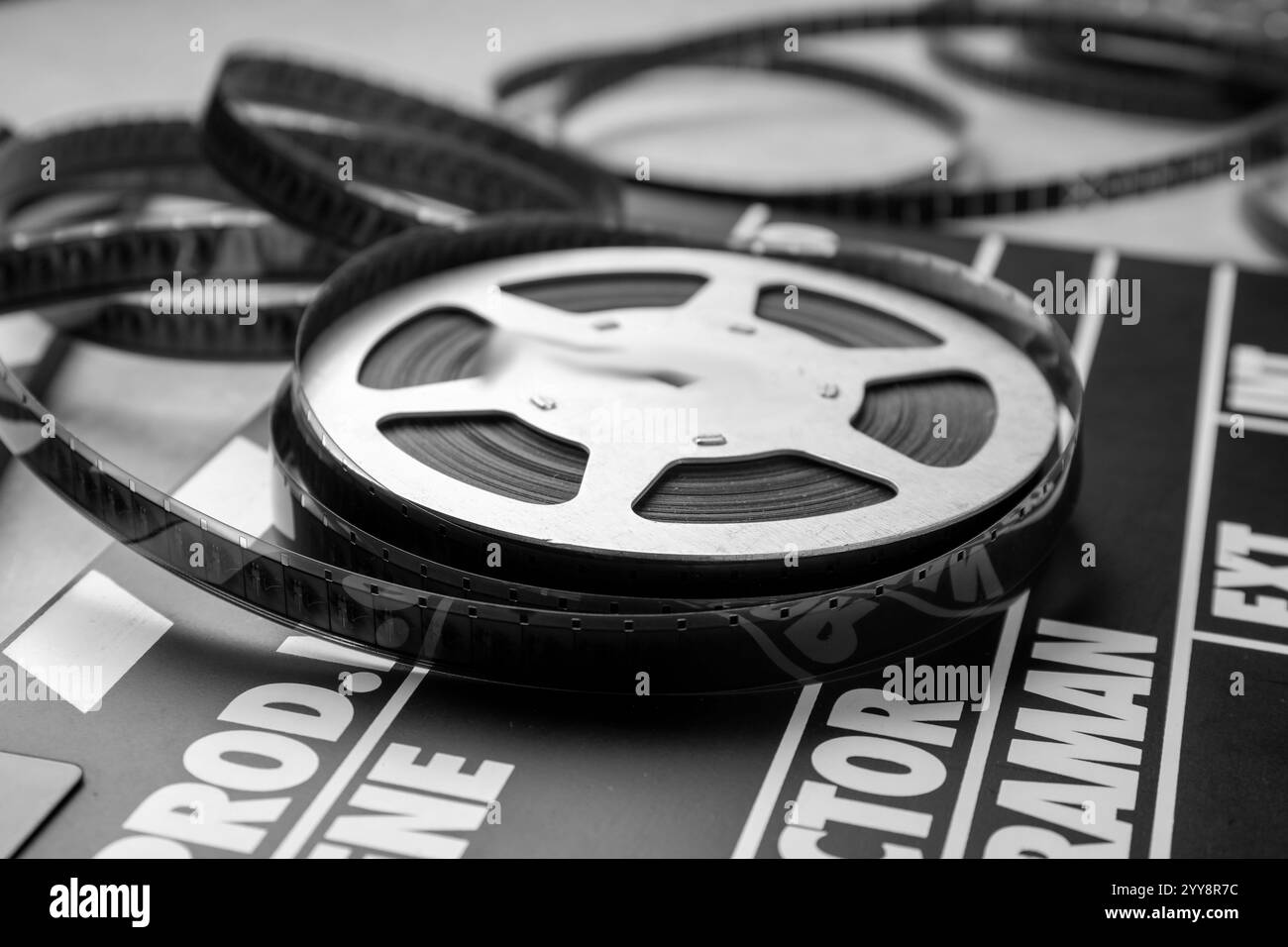 Clapper cinematografico e bobina di pellicola sul tavolo, primo piano Foto Stock