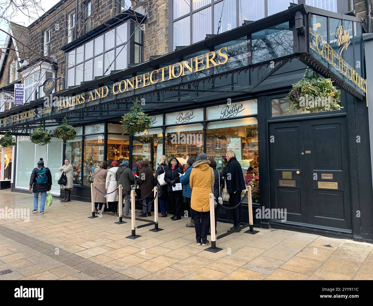Betty Tea Shop a Ilkley Yorkshire Inghilterra cibo che mangia tazza di tè pomeridiano, piattino, panna, focaccine, torte, cameriera all'interno dello stand shop persone - Immagine stock catturata con smartphone