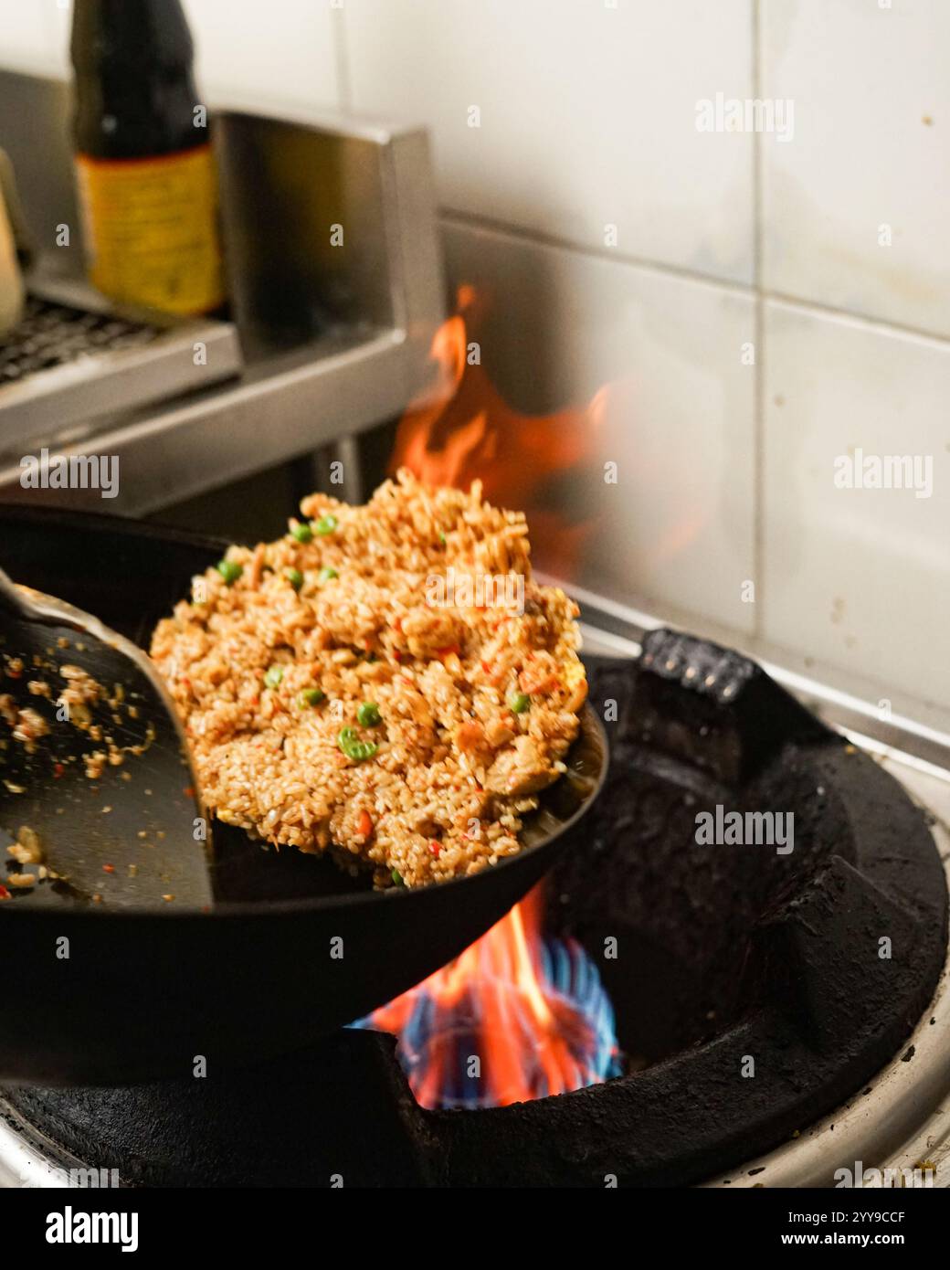🔥🍛 si è acceso per il gusto! Osserva la magia della cucina del wok mentre questo riso fritto in padella si trasforma in un tocco affumicato e baciato dalla fiamma! 🍳🔥 chi altro ama Foto Stock