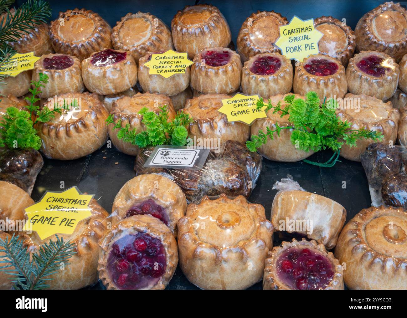 Torte speciali natalizie in vendita in una vetrina di macelleria per Natale, torta di selvaggina, torta di maiale, torta di tacchino e mirtilli rossi, cibo di stagione, Inghilterra, Regno Unito Foto Stock