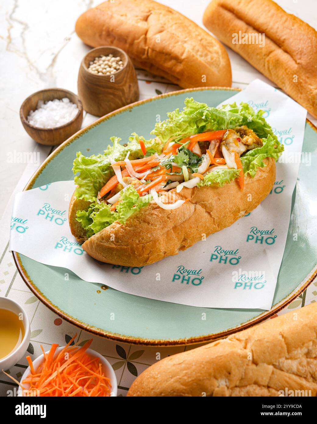 Un fresco e vibrante panino vietnamita bánh mì ripieno di verdure croccanti, erbe aromatiche e ripieno saporito, abbinato perfettamente a un rinfrescante frutto rosso Foto Stock