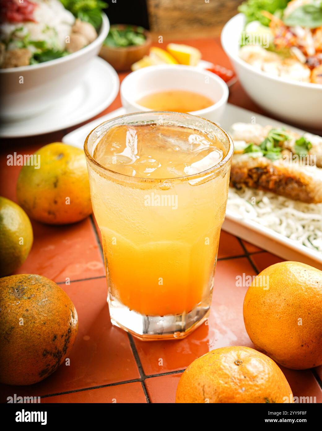 Rinfrescante tè nero freddo infuso con litchi dolce e guarnito con menta fresca, elegantemente presentato con tè a foglie sciolte e litchi intero Foto Stock