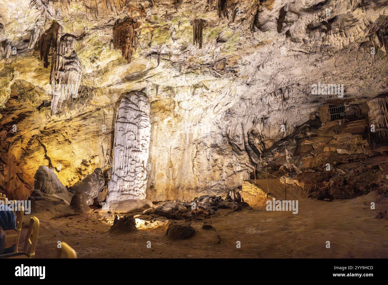 I turisti in treno ammirano le stalagmiti e le stalattiti illuminate all'interno della famosa grotta di postumia, una destinazione popolare in slovenia Foto Stock