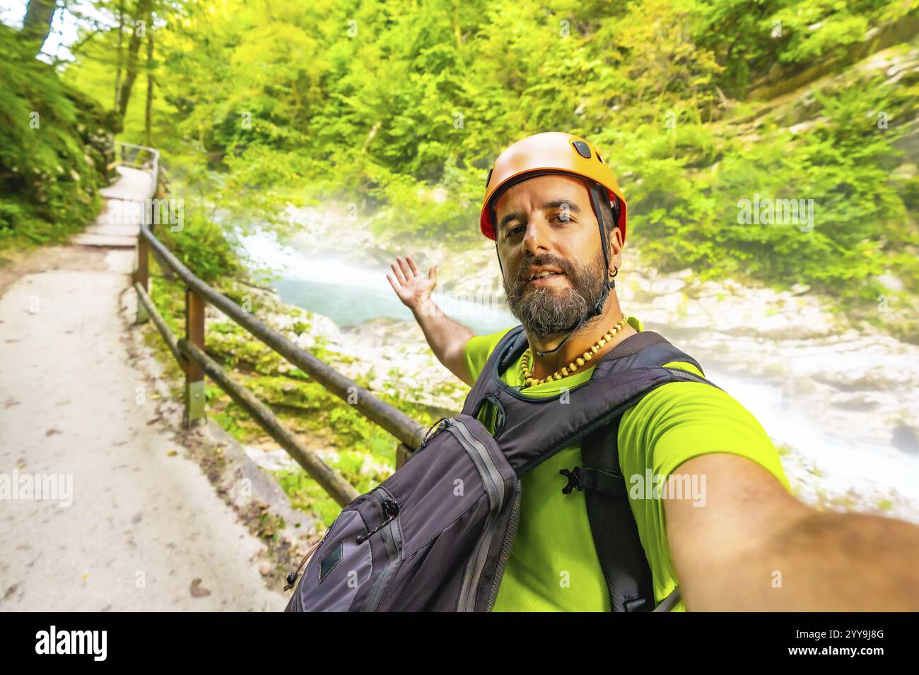 Il turista che indossa un casco arancione e uno zaino fa un selfie mentre visita la gola di vintgar vicino a Bled in slovenia Foto Stock