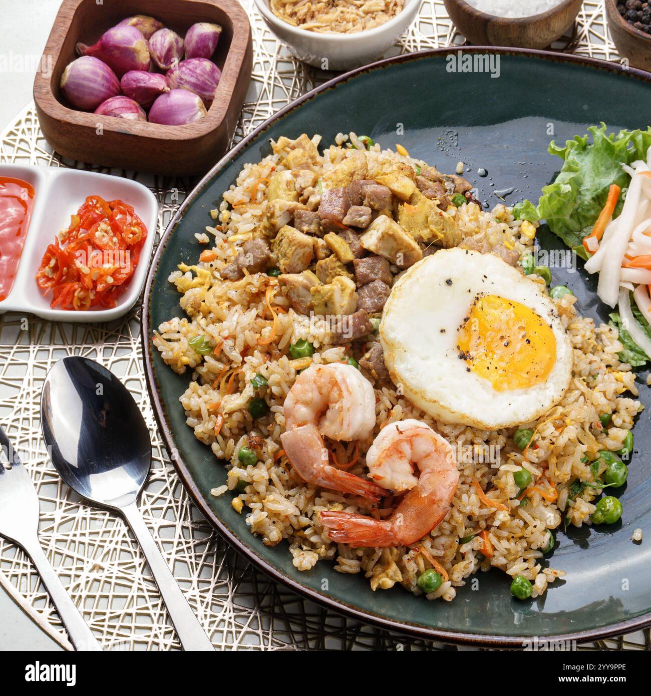 Un piatto vibrante di riso fritto vietnamita servito su una foglia di banana, ricco di sapore saporito, verdure croccanti e condito con erbe aromatiche Foto Stock