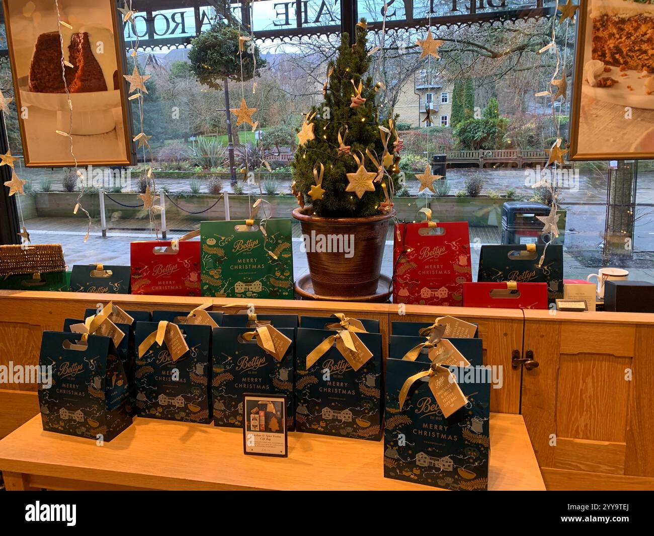 Betty Tea Shop a Ilkley Yorkshire Inghilterra cibo che mangia tazza di tè pomeridiano, piattino, panna, focaccine, torte, cameriera all'interno dello stand shop persone - Immagine stock catturata con smartphone