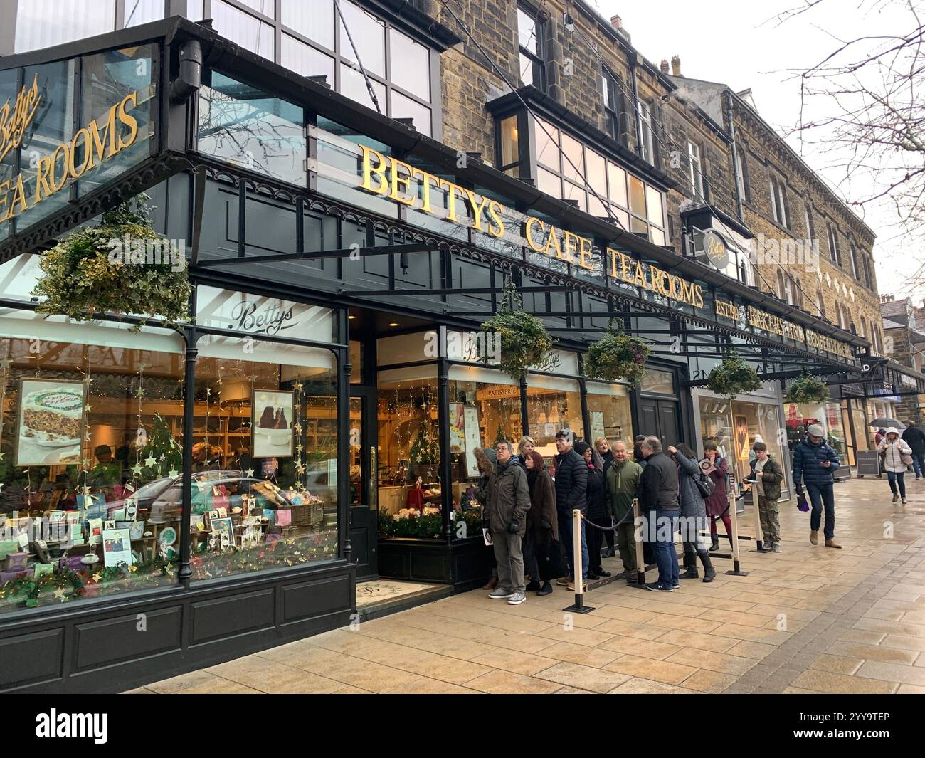 Betty Tea Shop a Ilkley Yorkshire Inghilterra cibo che mangia tazza di tè pomeridiano, piattino, panna, focaccine, torte, cameriera all'interno dello stand shop persone - Immagine stock catturata con smartphone