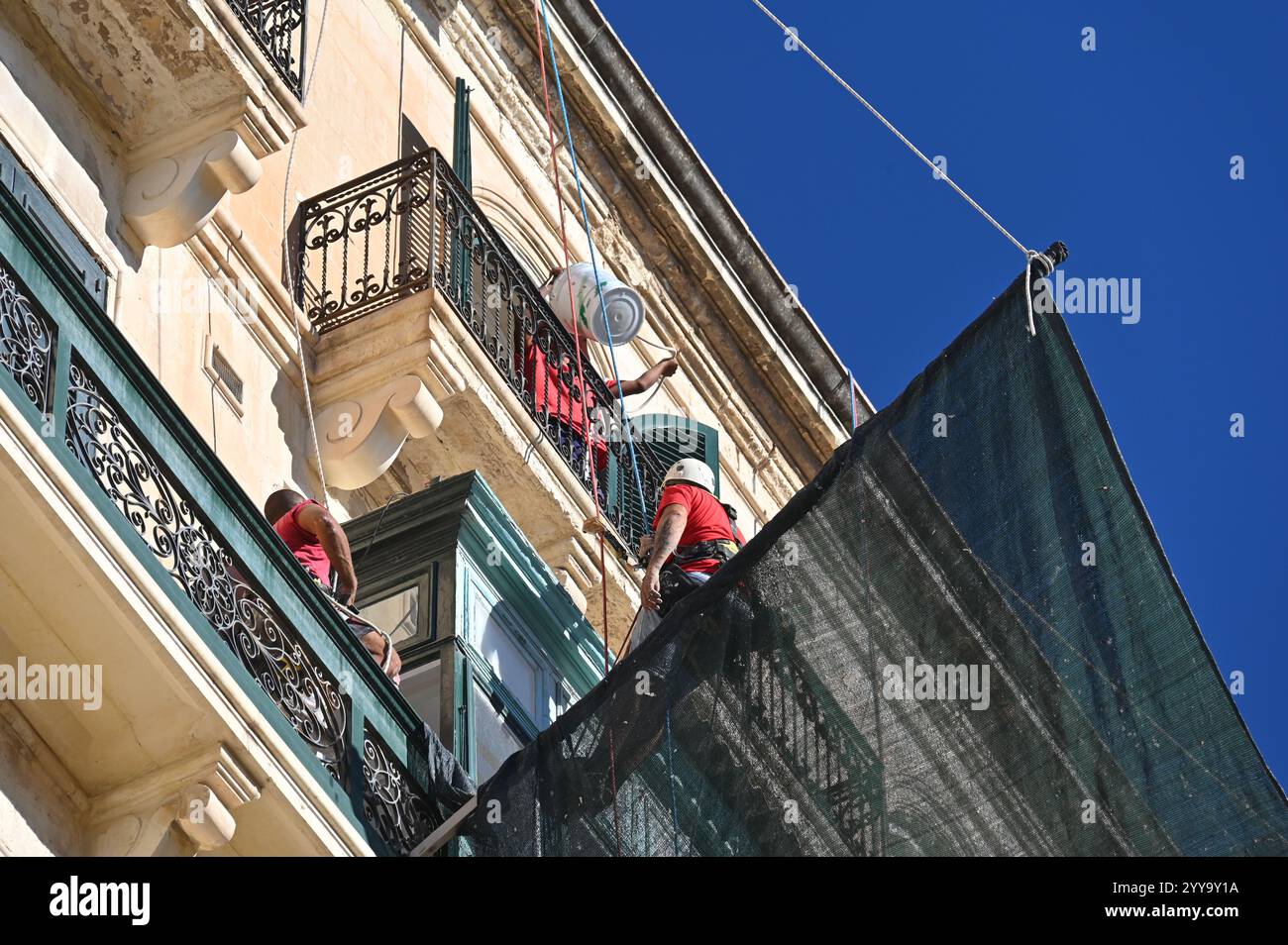 La Valletta, Malta - 12 ottobre 2024: Lavori di facciata assicurati con una rete nella città vecchia Foto Stock