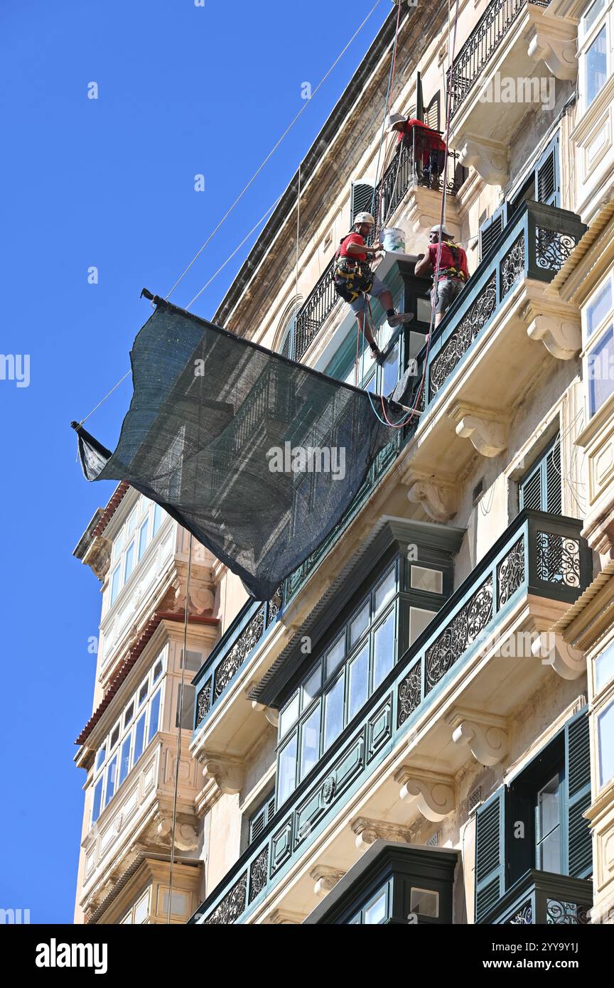 La Valletta, Malta - 12 ottobre 2024: Lavori di facciata assicurati con una rete nella città vecchia Foto Stock