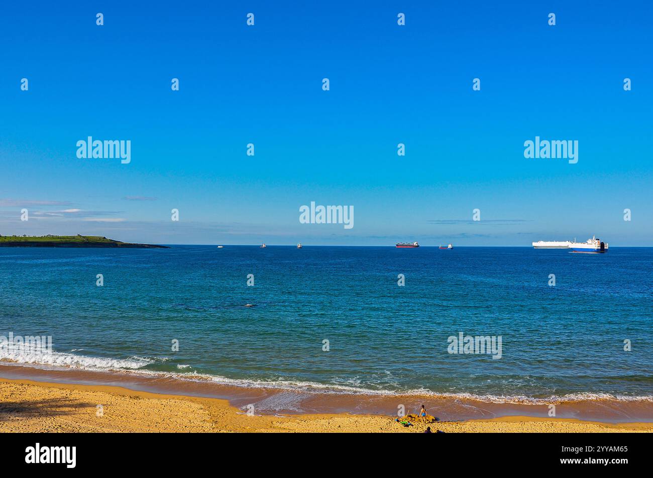 Cronache di carico: Traffico marittimo con navi da carico nella baia di Santander, visto dalla spiaggia di Sardinero Foto Stock